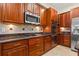 Spacious kitchen features wood cabinets, granite countertops and stainless steel appliances at 1097 Harmony Ln, Clermont, FL 34711