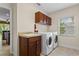 Spacious laundry room with full-size washer and dryer, a utility sink, and ample cabinet storage at 1097 Harmony Ln, Clermont, FL 34711