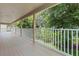 Spacious outdoor porch featuring white railings and serene green surroundings at 1097 Harmony Ln, Clermont, FL 34711