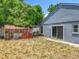 Backyard view features sliding glass doors, minimal landscaping, storage shed, and blue painted house at 1131 Tyler Lake Cir, Orlando, FL 32839