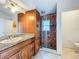 Bathroom showcases vanity with granite countertop and glass-enclosed shower with tile surround at 1131 Tyler Lake Cir, Orlando, FL 32839