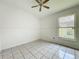 Bright bedroom with tile flooring, ceiling fan, and a decorative window at 1131 Tyler Lake Cir, Orlando, FL 32839