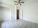 Bright bedroom with tile flooring, ceiling fan, and closet space at 1131 Tyler Lake Cir, Orlando, FL 32839