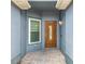 Covered entrance featuring a decorative wood door, tiled floor, and a small window at 1131 Tyler Lake Cir, Orlando, FL 32839
