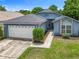Well-maintained blue single-story home with a two-car garage, neat landscaping, and walkway at 1131 Tyler Lake Cir, Orlando, FL 32839