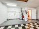 Functional garage space featuring checkered flooring, water heater, and access door to the house at 1131 Tyler Lake Cir, Orlando, FL 32839