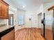 Kitchen with wood floors, stainless fridge, exterior door, and granite countertops at 1131 Tyler Lake Cir, Orlando, FL 32839
