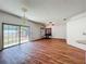 Living room with ceiling fan, sliding glass door to outside, window with blinds, and wood flooring at 1131 Tyler Lake Cir, Orlando, FL 32839