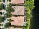 Aerial view of the house and neighborhood showcases tile roofs, landscaping, water view, and screened lanai at 11854 Delfina Ln, Orlando, FL 32827