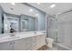 Bathroom with a double vanity, large mirror, and glass enclosed shower with white tile at 11854 Delfina Ln, Orlando, FL 32827