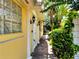 A side view of the home, showing the covered walkway with columns and tropical landscaping at 11854 Delfina Ln, Orlando, FL 32827