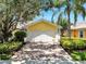 Charming home featuring a white two-car garage, beautiful landscaping, and a brick driveway at 11854 Delfina Ln, Orlando, FL 32827
