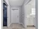 Neutral hallway featuring tile floors, storage and laundry through open doorways at 11854 Delfina Ln, Orlando, FL 32827