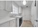 Well-lit laundry room featuring white cabinets, countertops, and a modern washer and dryer at 11854 Delfina Ln, Orlando, FL 32827