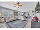 Spacious living room flows into a modern kitchen, featuring tile flooring and a large sectional sofa at 11854 Delfina Ln, Orlando, FL 32827
