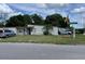 Cozy single-story home featuring a well-maintained lawn and mature trees at 1256 N Pine Hills Rd, Orlando, FL 32808