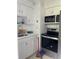 Efficient kitchen featuring white cabinets and modern stainless steel appliances at 1256 N Pine Hills Rd, Orlando, FL 32808