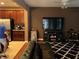 Living room featuring a TV, kitchen, ceiling fan, leather couch, and unique black and white rug at 13252 Vennetta Way, Windermere, FL 34786