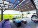 Private backyard featuring a patio with a pergola, comfortable outdoor seating, and a peaceful pond view at 13993 Title Way, Winter Garden, FL 34787