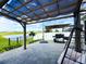 Backyard featuring a covered pergola, grill, egg chair, and peaceful water view at 13993 Title Way, Winter Garden, FL 34787