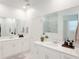 Elegant bathroom with dual vanities, mirrors, and shower; the space feels airy and clean at 13993 Title Way, Winter Garden, FL 34787