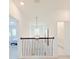 Upstairs hallway featuring an decorative light fixture, with views of a bedroom and bathroom at 13993 Title Way, Winter Garden, FL 34787