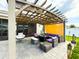 Inviting covered patio featuring a modern pergola, stylish seating, and cozy outdoor ambiance at 13993 Title Way, Winter Garden, FL 34787