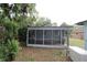 Enclosed back porch features a screened in enclosure and wood flooring at 16320 3Rd St, Umatilla, FL 32784