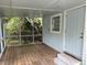 Cozy screened-in back porch with wood flooring and a view of the surrounding greenery at 16320 3Rd St, Umatilla, FL 32784