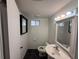 Bathroom featuring black tile flooring, a toilet, and vanity with a sink and lighted mirror at 16320 3Rd St, Umatilla, FL 32784