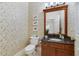 Well-decorated half bath with granite countertop and decorative wallpaper at 1741 Edgewater Dr, Mount Dora, FL 32757