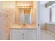 Cozy bathroom with decorative wallpaper, a functional vanity, and a well-lit mirror at 1741 Edgewater Dr, Mount Dora, FL 32757