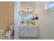 Bright bathroom with a classic vanity, decorative mirror, and stylish black-and-white tiled floor at 1741 Edgewater Dr, Mount Dora, FL 32757