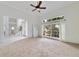 Bright living room featuring a large window, ceiling fan, and neutral carpeting at 1741 Edgewater Dr, Mount Dora, FL 32757