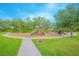 Community playground with slides, swings, and climbing structures, surrounded by green grass and mature trees at 1785 Red Canyon Dr, Kissimmee, FL 34744