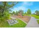 Community playground with swings, slides, picnic tables and walking path along the grassy green space at 1785 Red Canyon Dr, Kissimmee, FL 34744