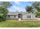 Charming single-story home featuring a modern entryway, gray siding, and a well-manicured lawn at 1850 North St, Longwood, FL 32750