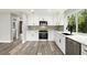 Modern kitchen with stainless steel appliances, white cabinets, and designer backsplash at 1850 North St, Longwood, FL 32750