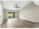 Bright, open living room with stylish wood floors, ceiling fan, and sliding glass doors to the backyard at 1850 North St, Longwood, FL 32750