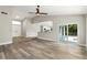 Bright, open living room boasts wood floors, a kitchen view, and sliding glass doors to the backyard at 1850 North St, Longwood, FL 32750