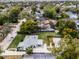 Aerial view of a charming home with well-kept lawn, detached garage, and long driveway in a lush neighborhood at 1911 Canton St, Orlando, FL 32803