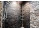Modern bathroom shower showcasing black slate tiles, providing a spa-like experience in this renovated home at 1911 Canton St, Orlando, FL 32803