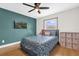 Bright bedroom features blue accent wall, ceiling fan, and large window at 2098 Heathwood St, Deltona, FL 32725