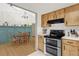 Well-equipped kitchen with stainless steel appliances and wooden cabinetry, open to the dining area at 2098 Heathwood St, Deltona, FL 32725