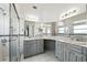 Well-lit bathroom featuring dual sinks, marble countertops, and tiled walk-in shower at 22 Bradford Ct, Kissimmee, FL 34758