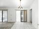 Open dining area features white tile flooring, chandelier, and glass doors to outdoor area at 22 Bradford Ct, Kissimmee, FL 34758