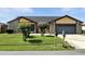 Home exterior with well-maintained lawn, mature bushes, and attached two-car garage at 22 Bradford Ct, Kissimmee, FL 34758