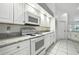 Bright kitchen featuring white cabinetry, marble countertops, and white appliances at 22 Bradford Ct, Kissimmee, FL 34758