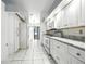 Bright kitchen featuring white cabinetry, marble countertops, and white tile flooring at 22 Bradford Ct, Kissimmee, FL 34758