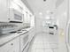 Bright eat-in kitchen boasts white cabinetry, countertops, and appliances with tile flooring at 22 Bradford Ct, Kissimmee, FL 34758